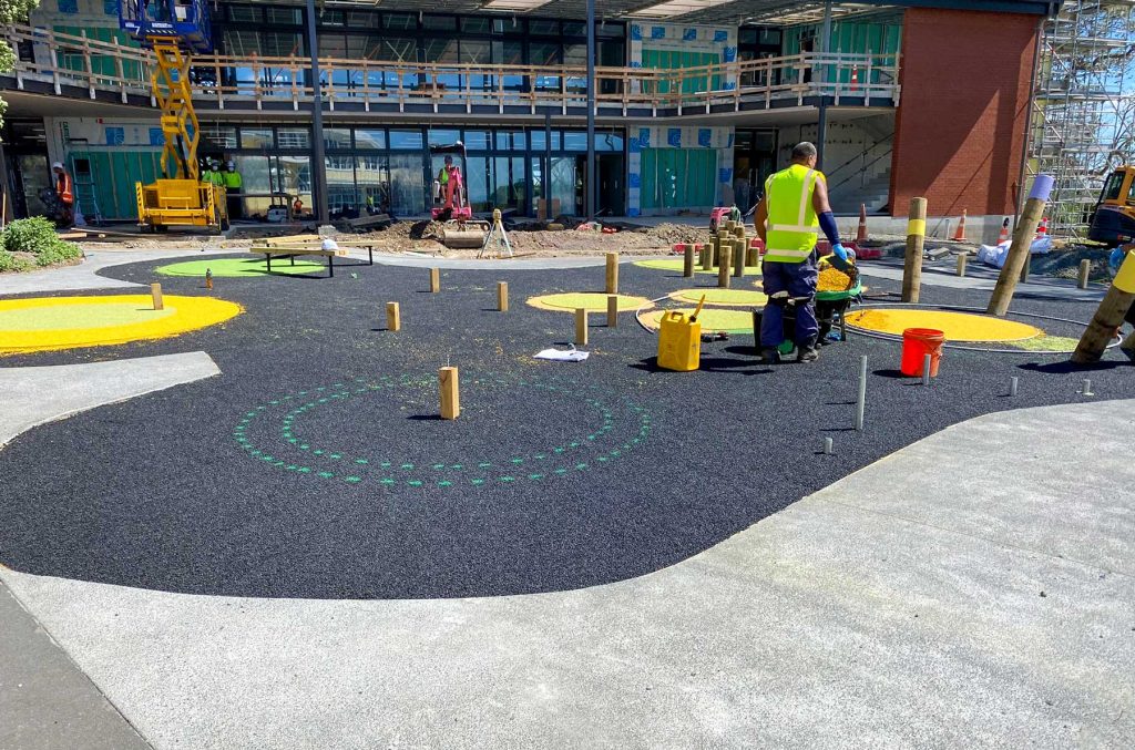 A school courtyard featuring artificial turf with seating.